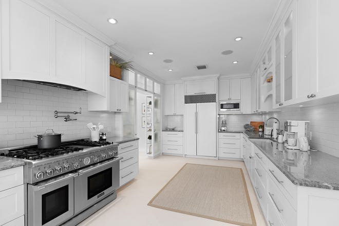 The kitchen has professional-grade appliances that include a refrigerator integrated into the Shaker-style cabinetry.