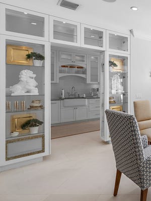 In the dining room, the space around the doorway into the kitchen is fitted with glass shelves.