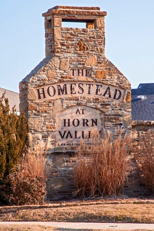 A free-standing sign marks the entrance to the Homestead at Horn Valley addition in Yukon.