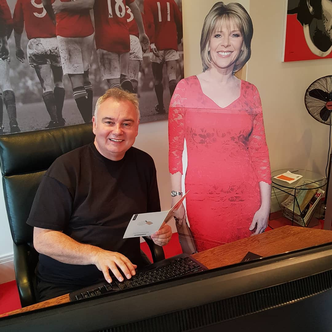 Eamonn in his office with a cut out of wife Ruth