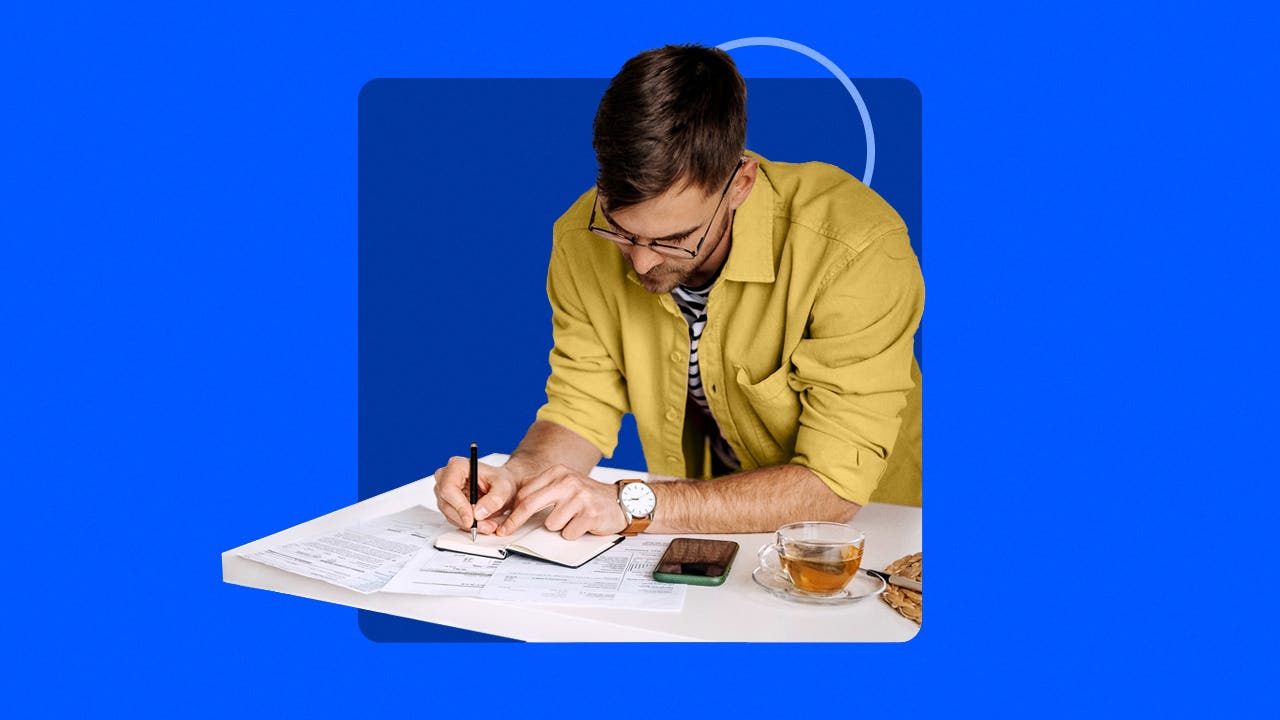 man working on financial paperwork, blue background