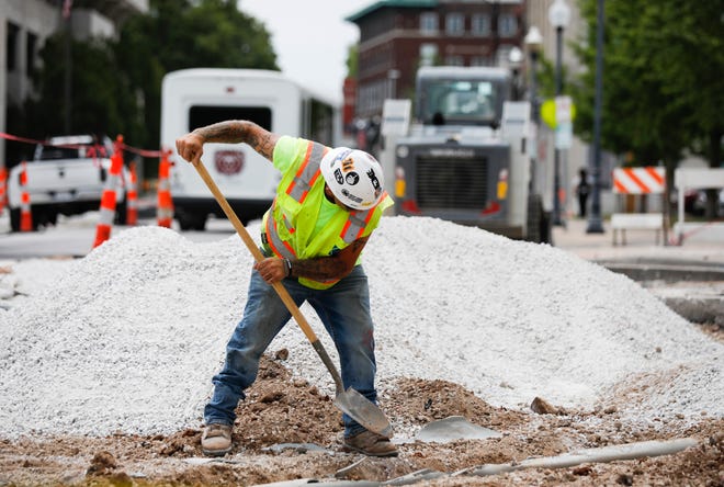 A construction worker digs up a pipe on Jefferson Avenue on Tuesday, June 27, 2023.