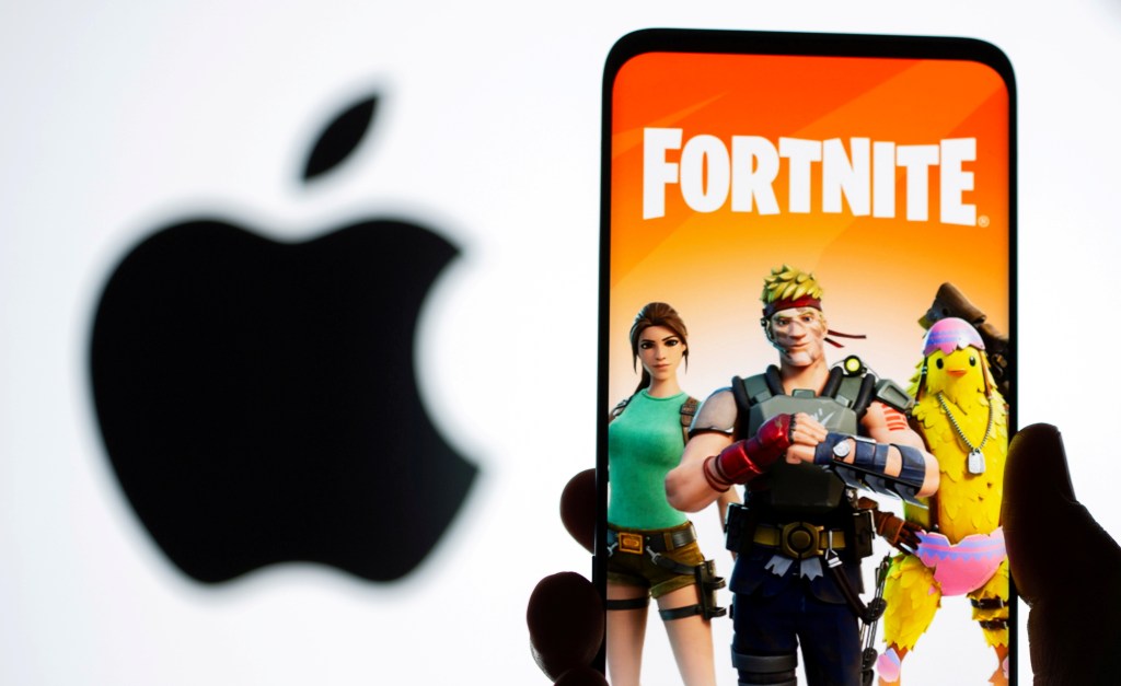 Fortnite game graphic is displayed on a smartphone in front of Apple logo