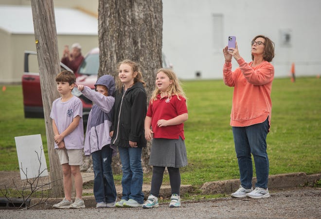 Celeste Hankins, right, the third-grade teacher at Sharkey-Issaquena Academy, and her class, left, watch at the new steeple for First Baptist Church of Rolling Fork as it's lifted off the flatbed truck Friday, March 22, 2024. The EF-4 tornado that ripped through the small Delta town on March 24, 2023, took down the previous steeple.