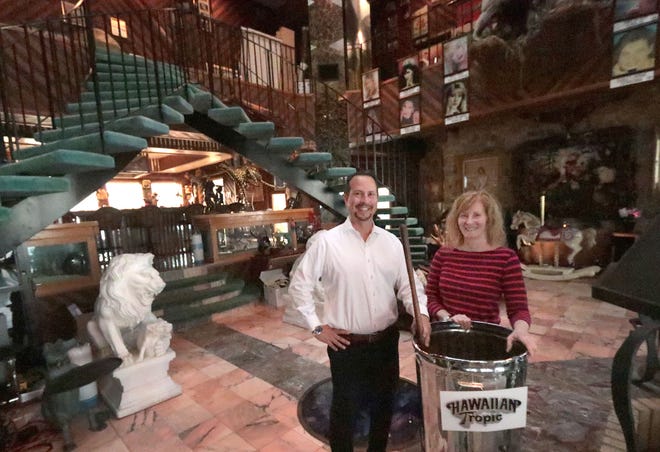 Bill Navarra, the broker/owner of Realty Pros Assured, and Linda Kramer, the longtime personal assistant to the late Ron Rice, stand next to the original garbage can that the Hawaiian Tropic founder used to mix his first batches of suntan lotion back in the late 1960s. The garbage can was later plated in silver. Navarra is the listing agent for Rice's oceanfront mansion at 175 Ocean Shore Blvd. in Ormond Beach which was put up for sale on Thanksgiving Day 2022. He and Kramer are seen here in the mansion's great room on Monday, Nov. 28, 2022.