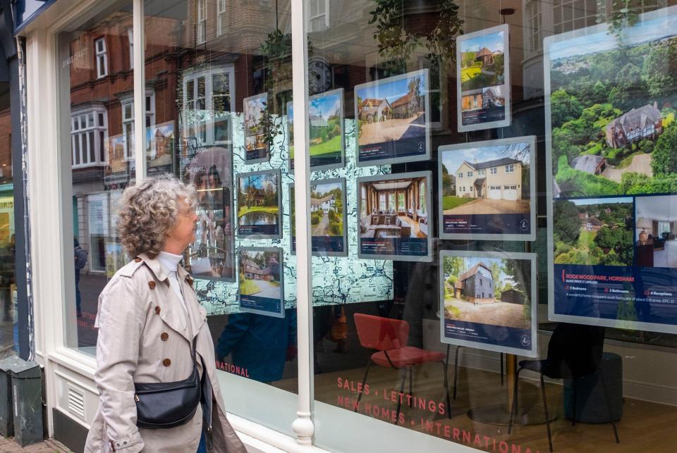 UK house prices A woman looks at properties for sale in Hamptons Estate Agents in West Street Horsham , West Sussex , England UK .