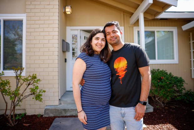 Husband and wife Nishant Sigh, right, and Apeqsha Dudani, left, stand in front of their new home in San Jose, Calif., on Friday, April 5, 2024. They are expecting their first child in July. (Shae Hammond/Bay Area News Group)