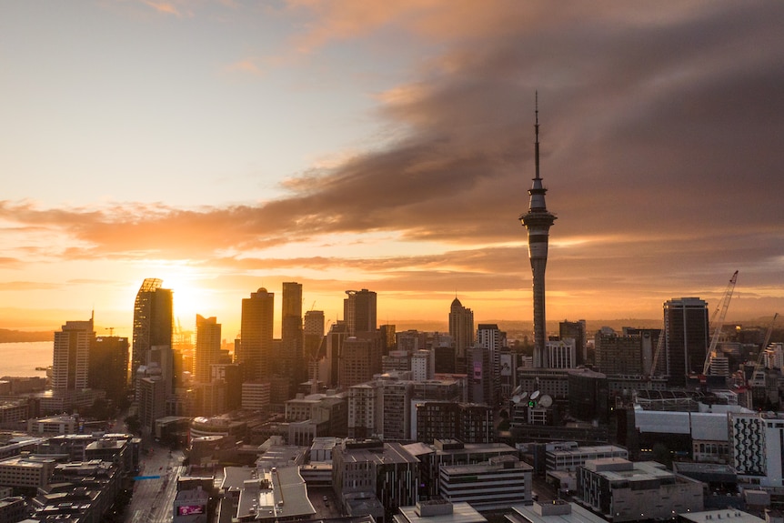 Auckland's skyline with a bright orange sunrise 