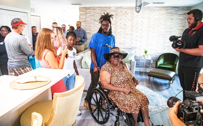 Myrtle Dillard reacts with members of her family at the unveiling of her new home in Fort Myers on Tuesday, May 7, 2024. Lee BIA Builders Care, a non-profit and Stevens Construction along with the help of 48 company partners tore down her old dilapidated home and rebuilt a new one in its place in just 48 days. Pushing Dillard is grandson, Jonathan Harris.