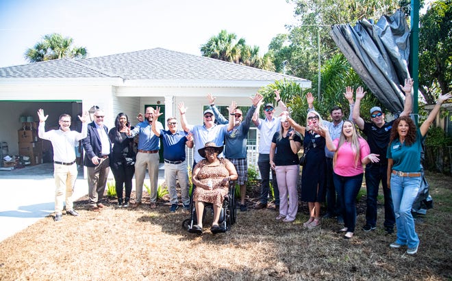 Myrtle Dillard reacts with sits for a portrait with leaders from Builders Care, Stevens Construction, construction partners and elected officials at the unveiling of her new home in Fort Myers on Tuesday, May 7, 2024. Lee BIA Builders Care, a non-profit and Stevens Construction along with the help of 48 company partners tore down her old dilapidated home and rebuilt a new one in its place in just 48 days.